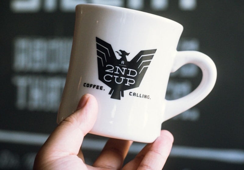 Hand holding an A 2nd Cup coffee mug